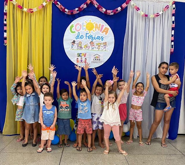 Foto de varias crianças levantando as mãos para o alto.