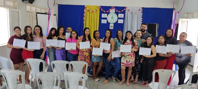 Foto do prefeito Taiano Martins e varias mulheres segurando seus certificados.