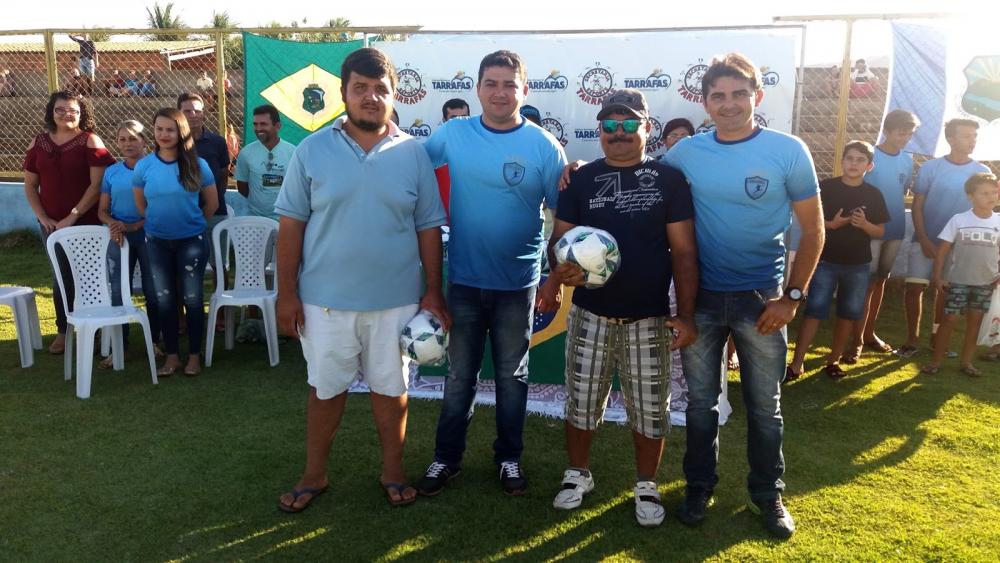 Prefeito Taiano e Secretário de Esportes de Tarrafas entregando bolas de futebol para dois homens